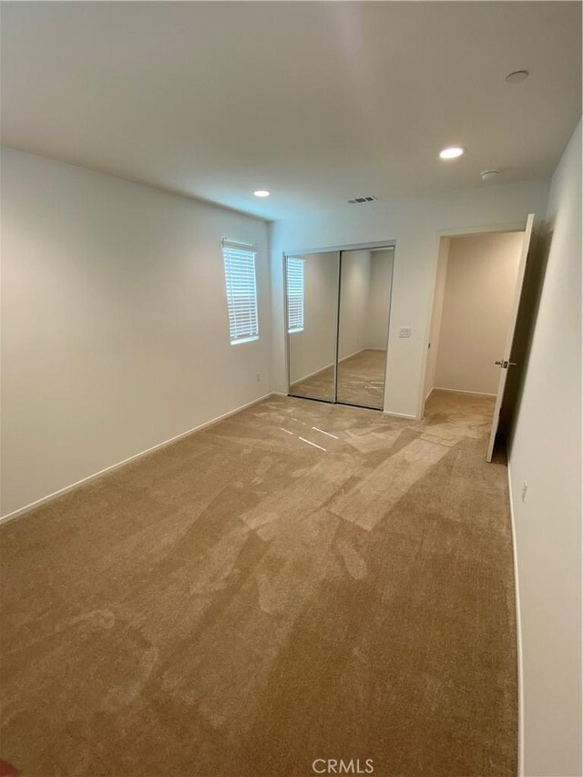 13110 Rosamond Ct, Hesperia, CA 92395 - unfurnished bedroom featuring light carpet, recessed lighting, and a closet