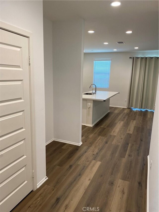 13110 Rosamond Ct, Hesperia, CA 92395 - corridor featuring dark wood-style floors, a sink, recessed lighting, and baseboards