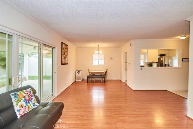 2624 W Cherry Ave, Fullerton, CA 92833 - living room featuring light wood-type flooring, a chandelier, ornamental molding, and a textured ceiling