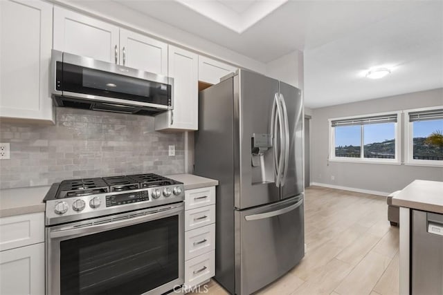 kitchen featuring decorative backsplash, appliances with stainless steel finishes, and light countertops