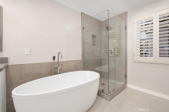 full bathroom featuring a soaking tub, tile patterned floors, and a stall shower