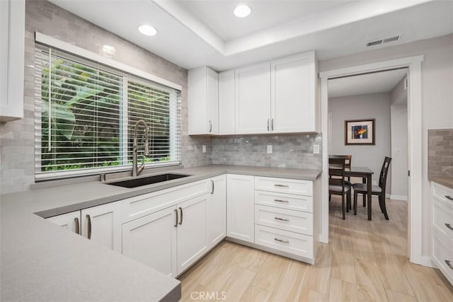 23875 Catamaran Way Unit 51, Laguna Niguel, CA 92677 - kitchen with white cabinetry, tasteful backsplash, light countertops, recessed lighting, and a tray ceiling