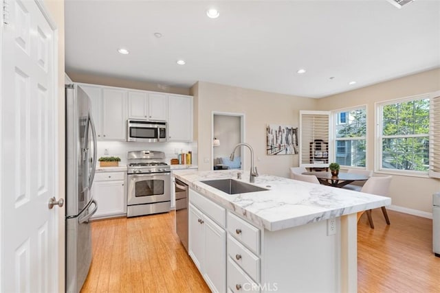 37 Rumford St, Ladera Ranch, CA 92694 - kitchen with stainless steel appliances, a sink, white cabinets, light wood-type flooring, and recessed lighting