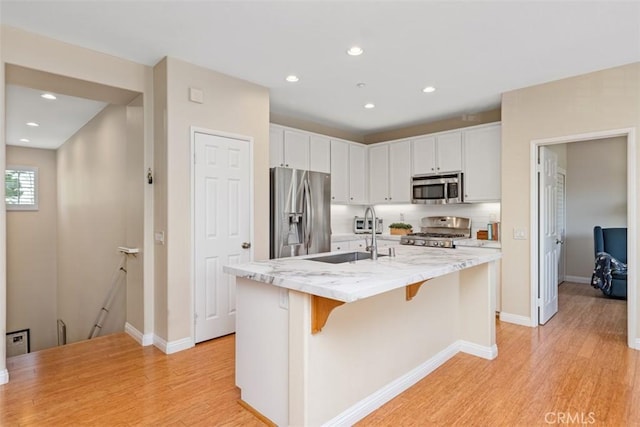 37 Rumford St, Ladera Ranch, CA 92694 - kitchen with appliances with stainless steel finishes, a sink, light wood-style floors, recessed lighting, and white cabinetry