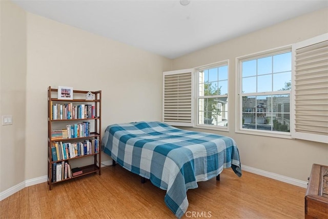 bedroom with baseboards and wood finished floors