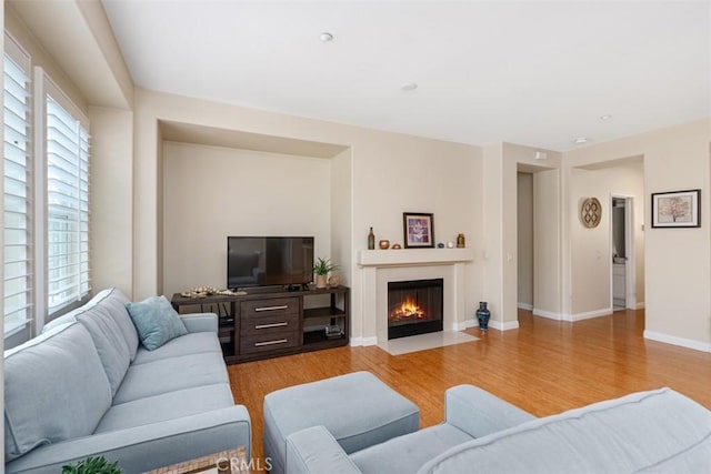 37 Rumford St, Ladera Ranch, CA 92694 - living area with light wood-type flooring, a fireplace with flush hearth, and baseboards