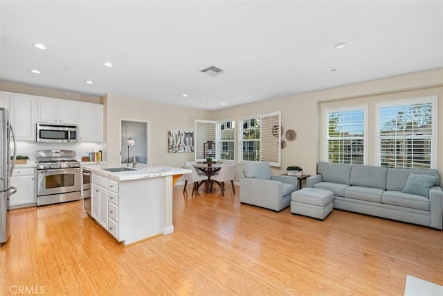 37 Rumford St, Ladera Ranch, CA 92694 - kitchen with appliances with stainless steel finishes, a sink, light wood-style floors, white cabinetry, and recessed lighting