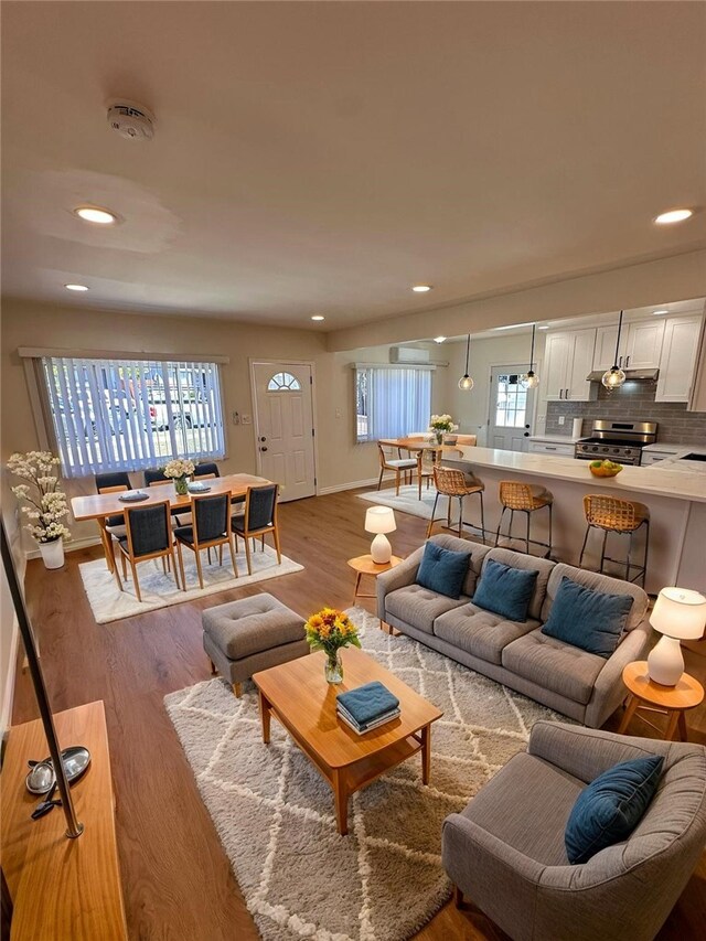 living area featuring recessed lighting, baseboards, and wood finished floors
