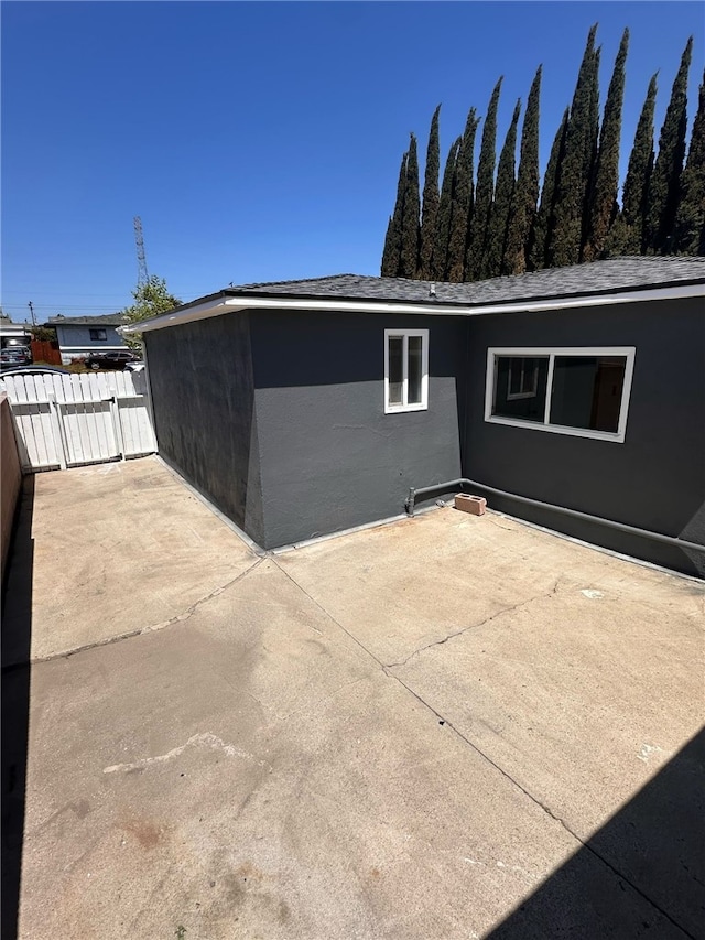 back of property with fence, a gate, and a patio area