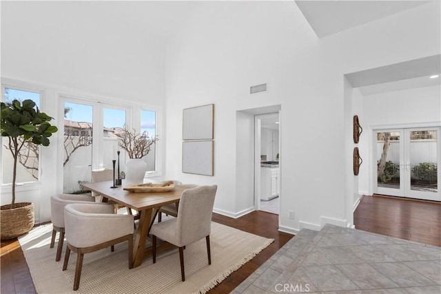 31 Terraza Del Mar, Dana Point, CA 92629 - dining area featuring hardwood / wood-style floors, french doors, a towering ceiling, and baseboards
