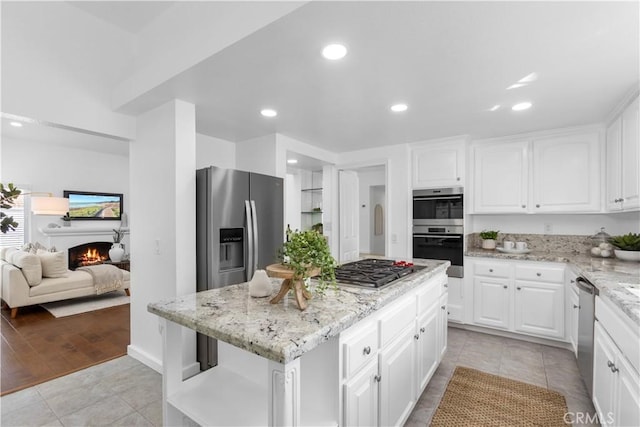 31 Terraza Del Mar, Dana Point, CA 92629 - kitchen with appliances with stainless steel finishes, a center island, light stone counters, white cabinets, and recessed lighting