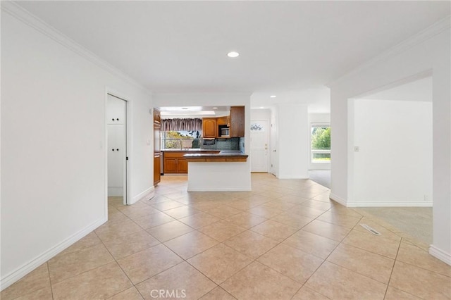 kitchen featuring crown molding, light tile patterned flooring, and open floor plan