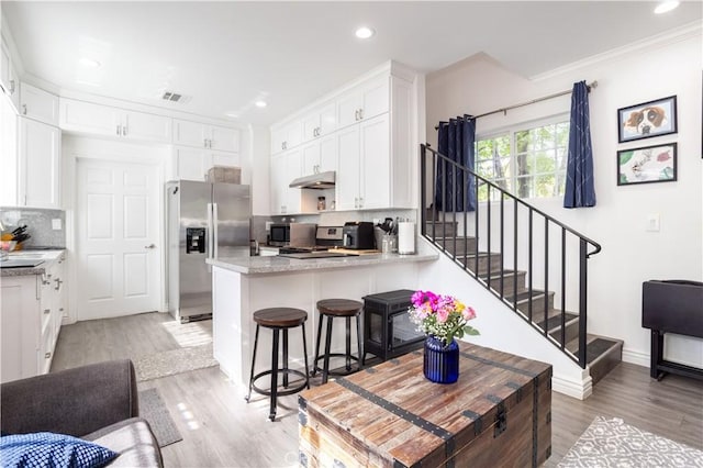 7744 Rhea Ave, Reseda, CA 91335 - kitchen with appliances with stainless steel finishes, under cabinet range hood, a peninsula, backsplash, and white cabinetry