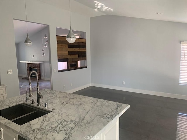 18810 Oakview Way, Lake Elsinore, CA 92530 - kitchen featuring light stone counters, a brick fireplace, white cabinets, hanging light fixtures, and lofted ceiling