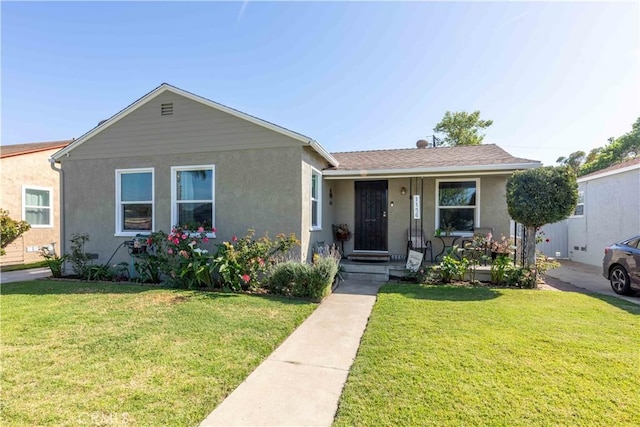 view of front of house featuring a front lawn and stucco siding