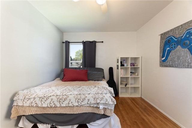 bedroom featuring wood finished floors and baseboards