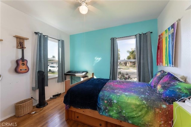bedroom featuring baseboards, wood finished floors, and ceiling fan