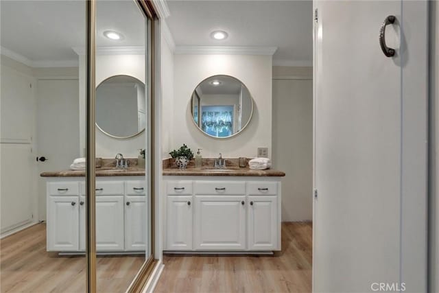bathroom with vanity, ornamental molding, and wood finished floors