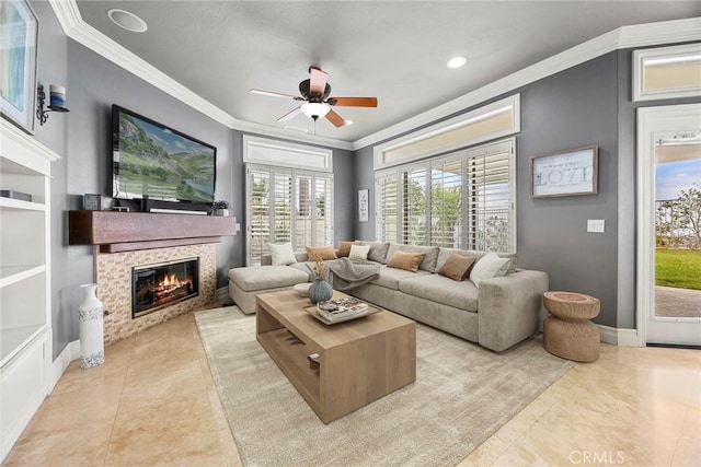 living room featuring ceiling fan, a tile fireplace, baseboards, ornamental molding, and recessed lighting