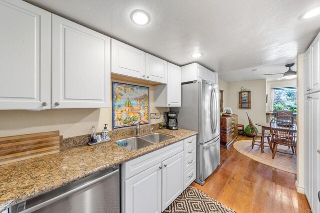 2564 Navarra Dr Unit 113, Carlsbad, CA 92009 - kitchen with a sink, stainless steel appliances, light wood-type flooring, white cabinetry, and recessed lighting