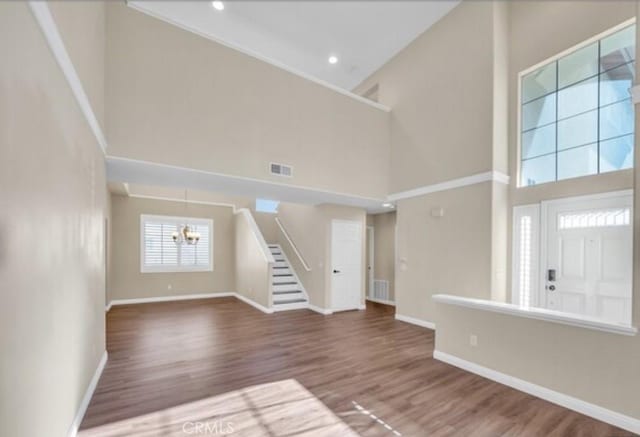 49 El Cencerro, Rancho Santa Margarita, CA 92688 - unfurnished living room with baseboards, a notable chandelier, visible vents, and a towering ceiling