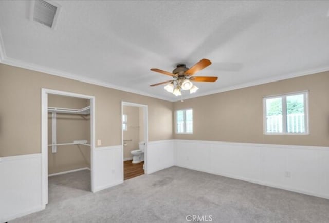 49 El Cencerro, Rancho Santa Margarita, CA 92688 - unfurnished bedroom with visible vents, crown molding, a wainscoted wall, a spacious closet, and carpet