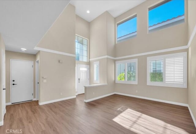 49 El Cencerro, Rancho Santa Margarita, CA 92688 - unfurnished living room with baseboards, wood finished floors, and a towering ceiling