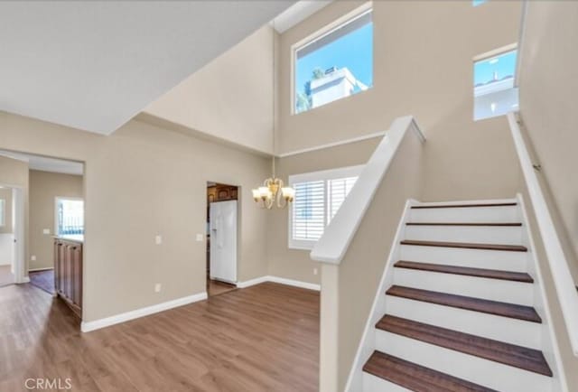 49 El Cencerro, Rancho Santa Margarita, CA 92688 - stairs featuring baseboards, a high ceiling, wood finished floors, and a chandelier