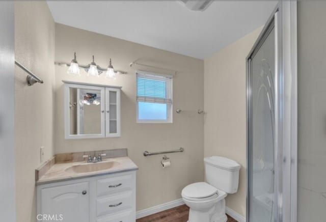 49 El Cencerro, Rancho Santa Margarita, CA 92688 - bathroom featuring a stall shower, wood finished floors, vanity, baseboards, and toilet
