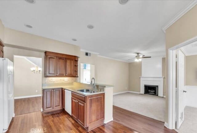 49 El Cencerro, Rancho Santa Margarita, CA 92688 - kitchen featuring a peninsula, wood finished floors, white appliances, a sink, and ceiling fan with notable chandelier