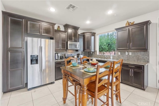 4250 W 5th St, Santa Ana, CA 92703 - kitchen featuring light tile patterned floors, visible vents, dark brown cabinetry, and appliances with stainless steel finishes