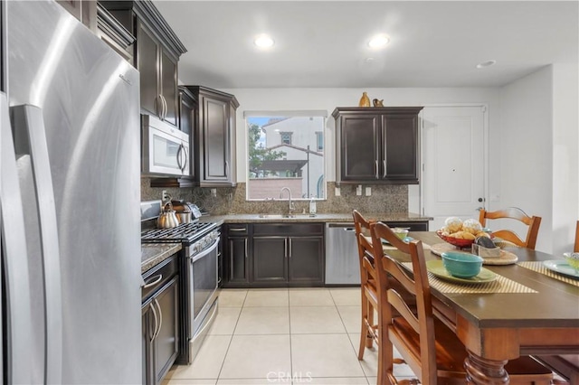 4250 W 5th St, Santa Ana, CA 92703 - kitchen with a sink, dark stone counters, tasteful backsplash, light tile patterned flooring, and appliances with stainless steel finishes