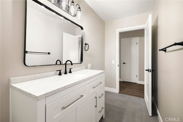 bathroom with tile patterned floors, baseboards, and vanity