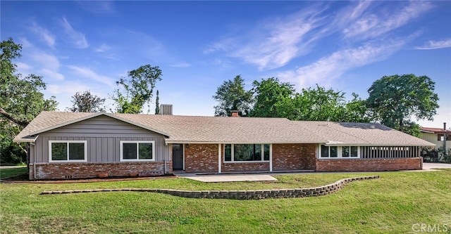 ranch-style house with a front lawn, a chimney, and brick siding