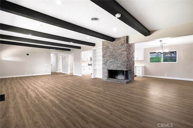 unfurnished living room featuring dark wood finished floors, visible vents, beam ceiling, baseboards, and a fireplace