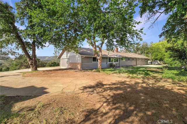 exterior space with board and batten siding, driveway, and a garage