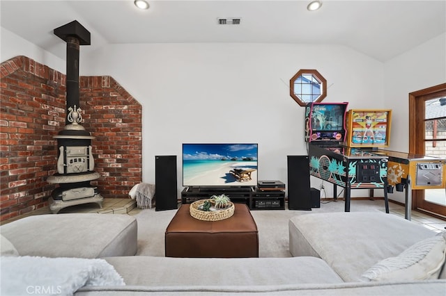 living room featuring a wood stove, vaulted ceiling, visible vents, and recessed lighting