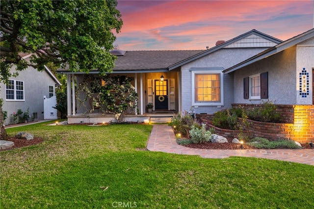 single story home with a front lawn, brick siding, and stucco siding
