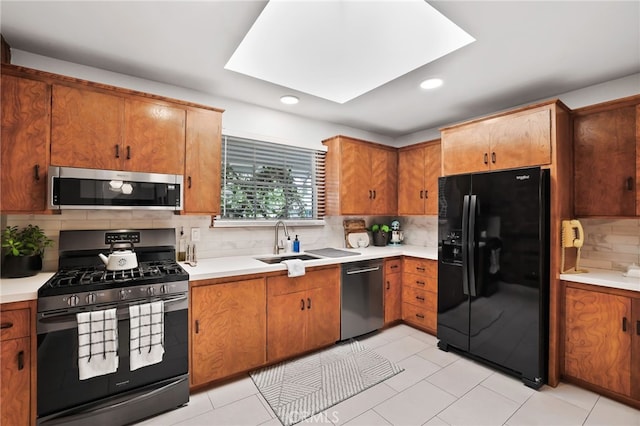 kitchen with recessed lighting, stainless steel appliances, light countertops, a sink, and tasteful backsplash