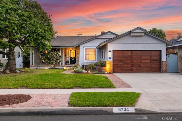 ranch-style house featuring stucco siding, driveway, a front lawn, and a garage