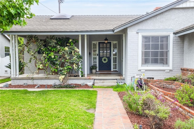 doorway to property with a lawn, brick siding, and a shingled roof