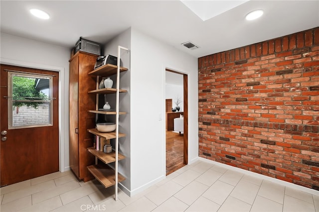interior space with brick wall, baseboards, visible vents, and recessed lighting