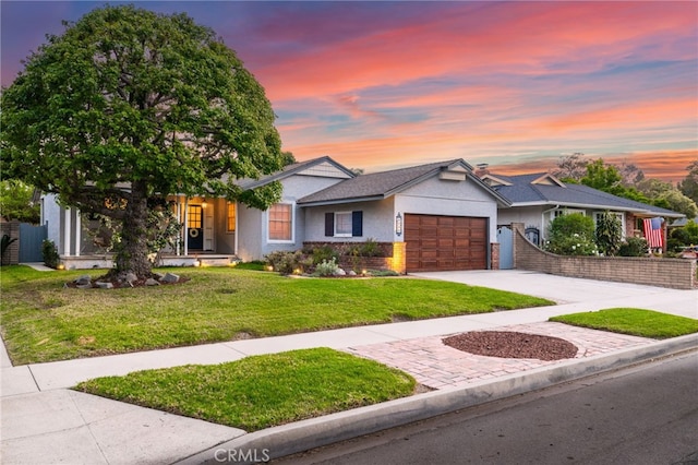 view of front of home featuring fence, a yard, stucco siding, driveway, and a garage