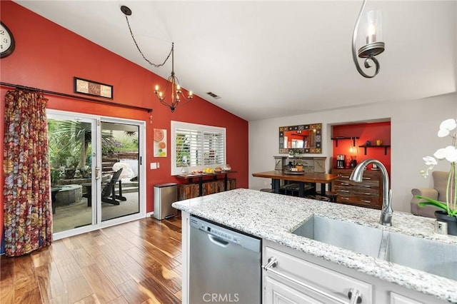 kitchen featuring white cabinets, a sink, wood finished floors, lofted ceiling, and stainless steel dishwasher