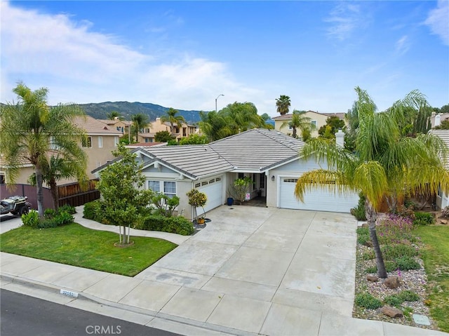 single story home with fence, a residential view, an attached garage, concrete driveway, and a tiled roof