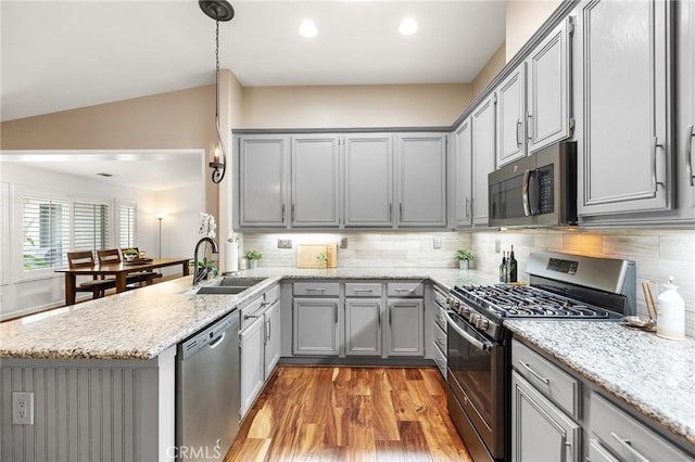 kitchen featuring gray cabinetry, stainless steel appliances, a peninsula, and a sink