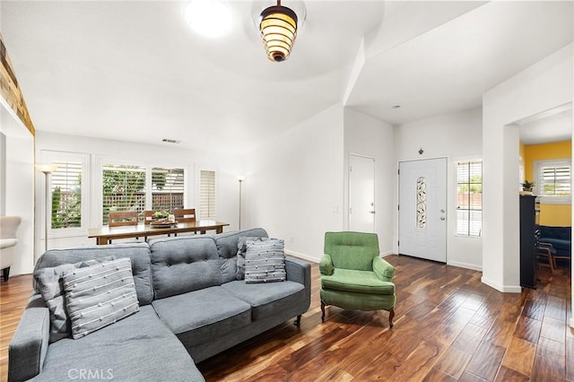 living area featuring baseboards, wood finished floors, and visible vents