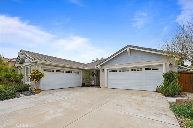 single story home featuring fence, a garage, stucco siding, concrete driveway, and a tiled roof