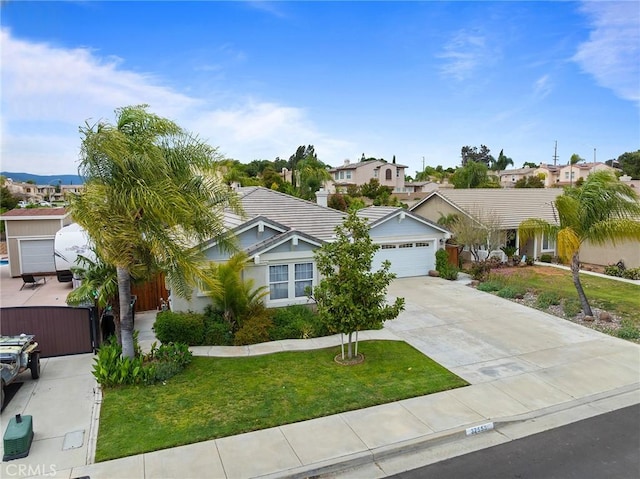 ranch-style house with a residential view, fence, concrete driveway, and a front yard