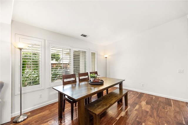 dining space with baseboards, dark wood-type flooring, and visible vents